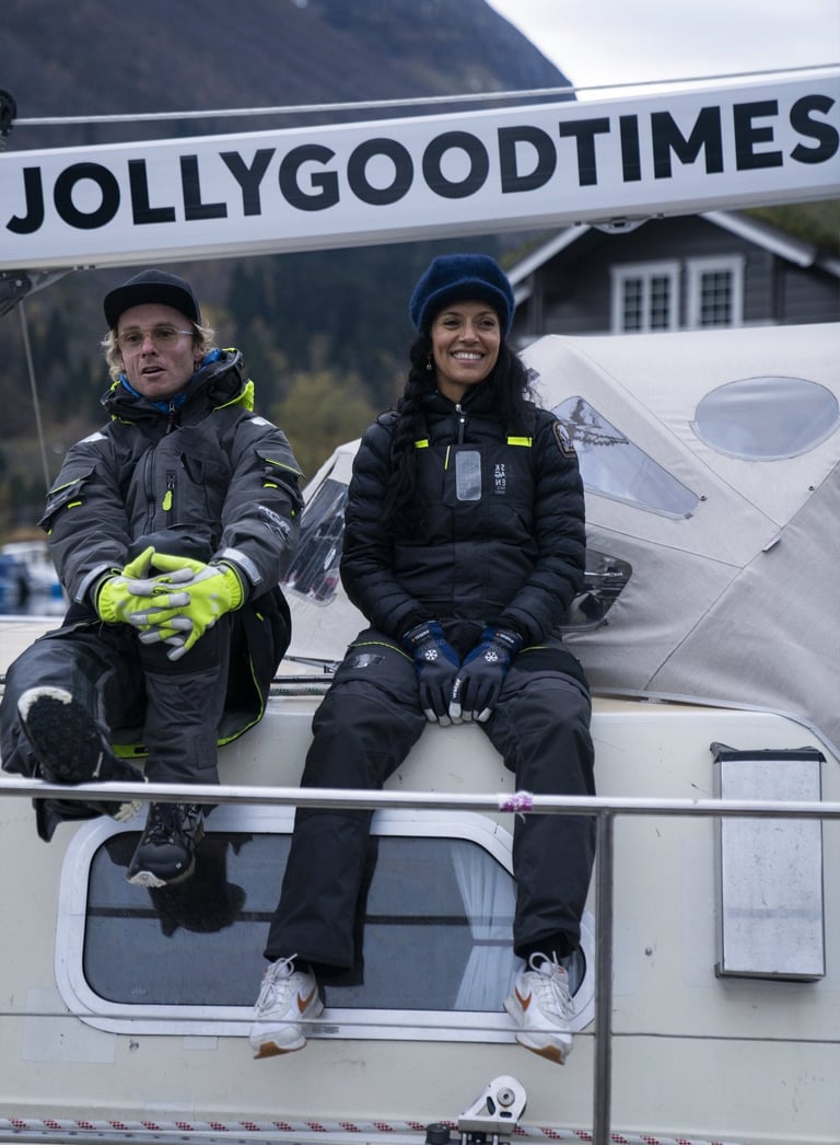 two people sitting on a boat and smiling happy | Jolly Good Times Sailing in Norway