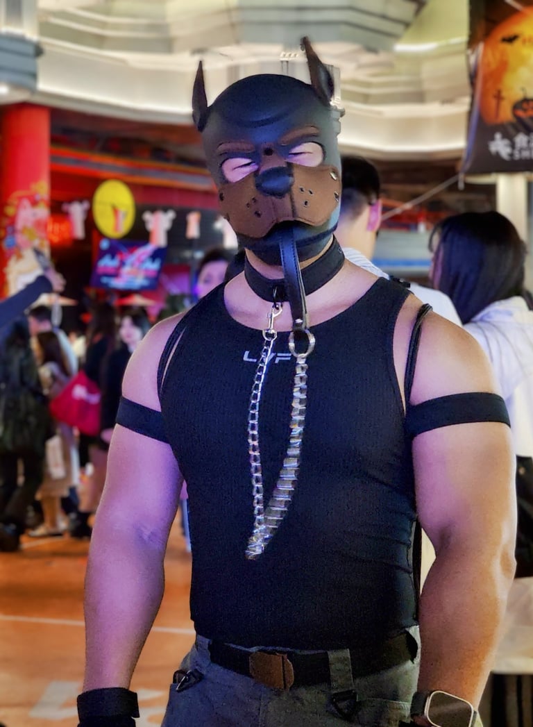 Man in pup mask with leash.