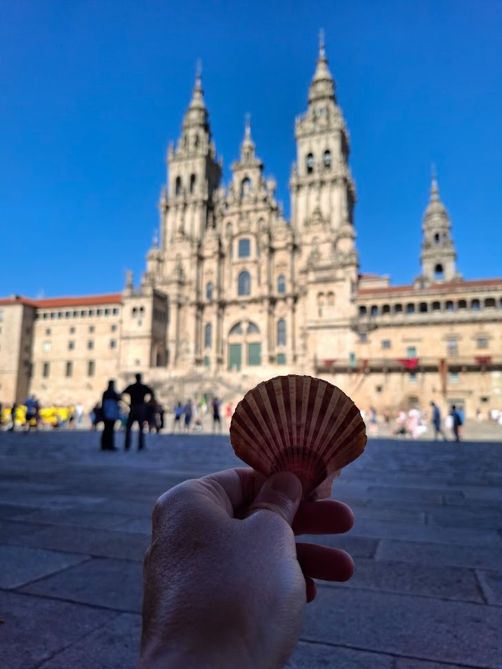 a person holding a shell shellfish in front of a large building