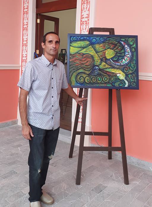 The artist standing in front of a painting