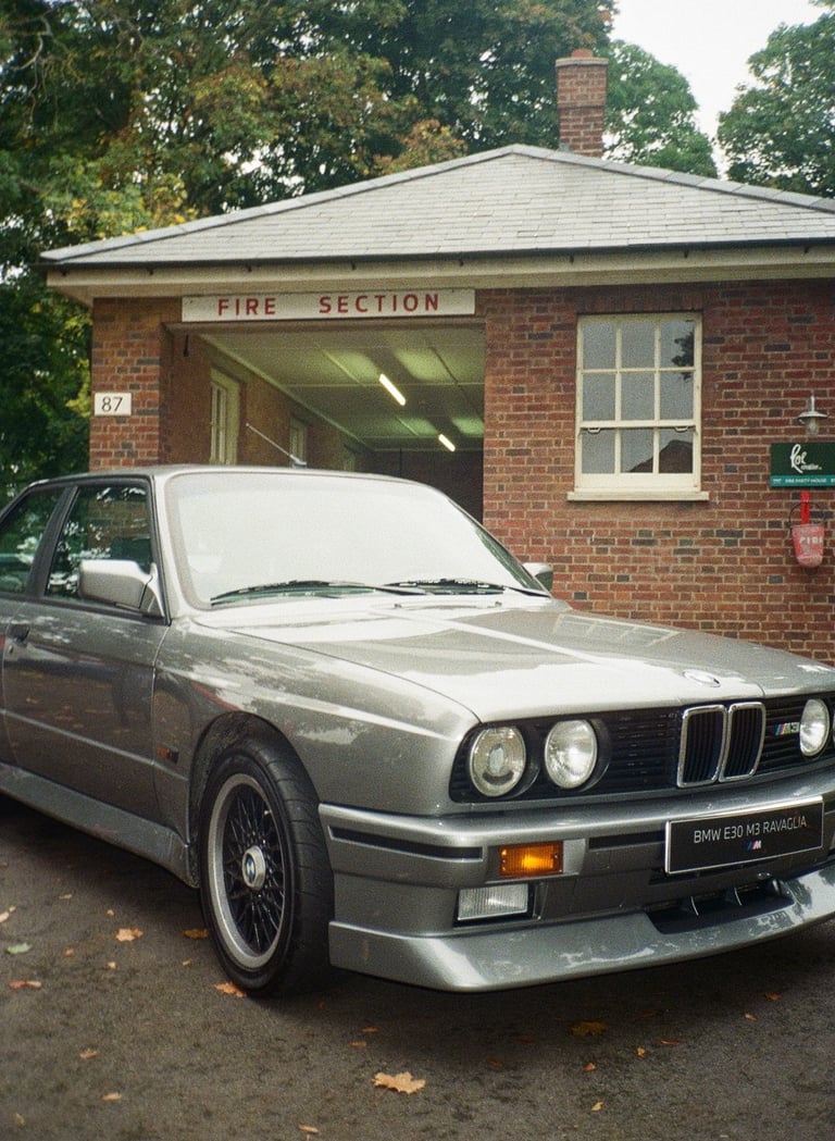 a classic BMW parked in front of a brick building