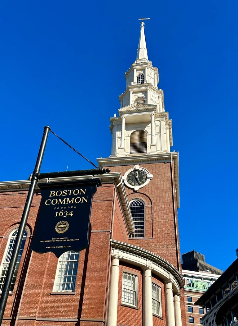 a church steeple with a sign saying Boston common in front