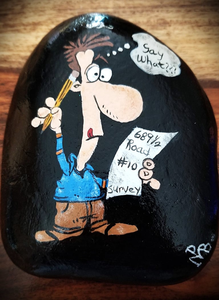 Cartoon painted on a rock of a man surveying a crazy address