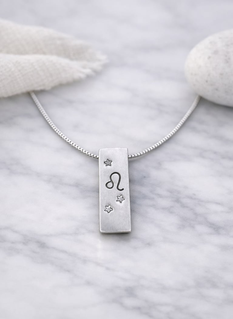 Handmade 999 silver Leo zodiac necklace with a vertical bar pendant on a marble surface.