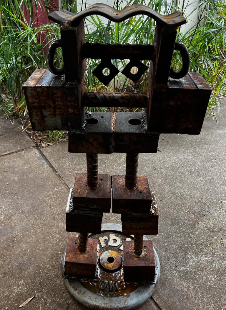Rustic industrial metal robot sculpture made from salvaged iron and weight plates.