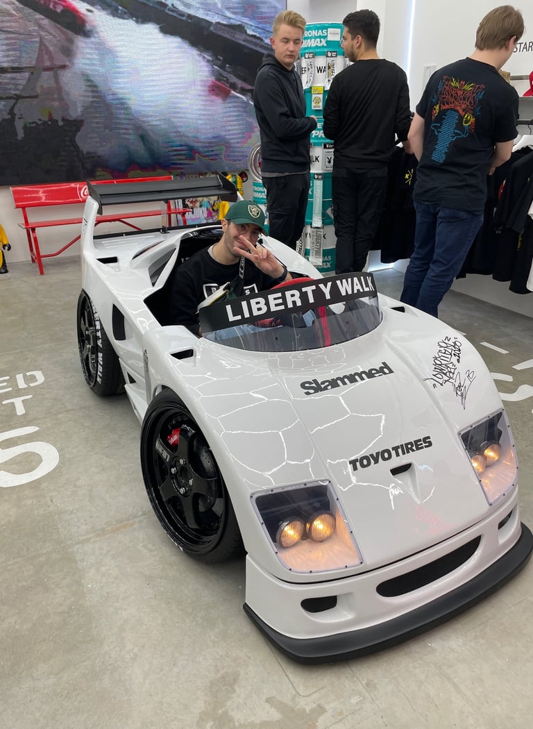 Homme assis dans une voiture miniature blanche