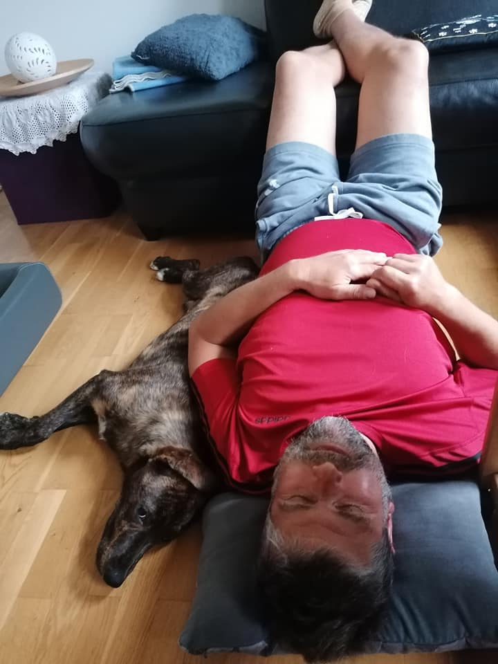 Martin und Milo liegen entspannt auf dem Boden. Milo übt die Lagerung ganz dicht bei Martin.