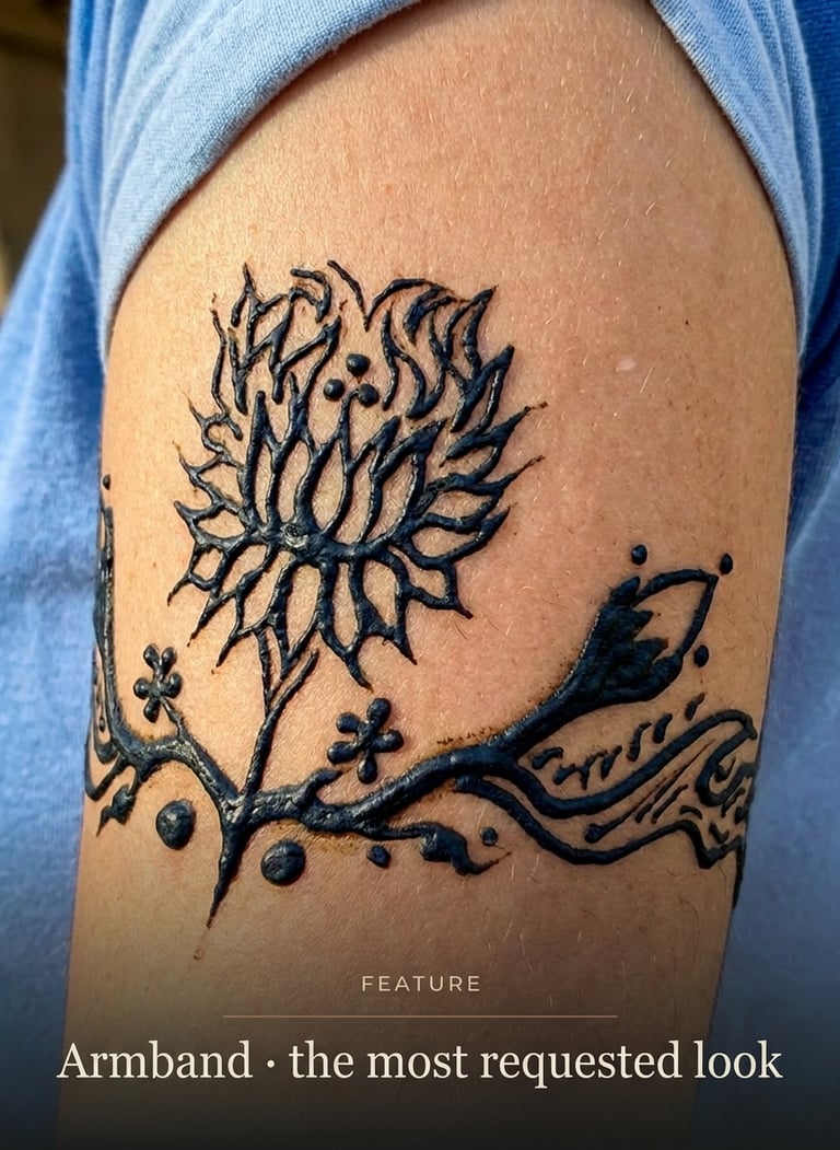 A bold black floral temporary tattoo design across a woman's lower belly and hip area.