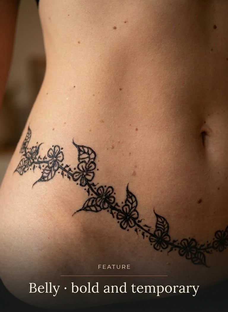 A detailed temporary floral tattoo on a woman's belly and hip featuring black ink flowers and leaves.