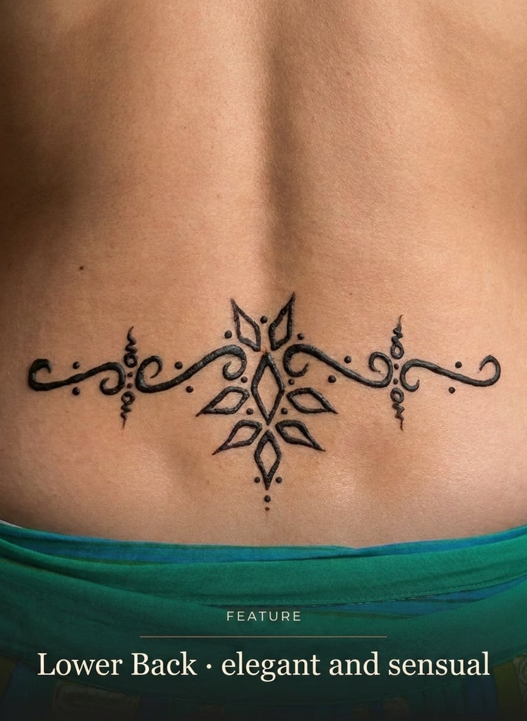 Elegant black ink ornamental tattoo design on a person's lower back featuring symmetrical floral patterns.