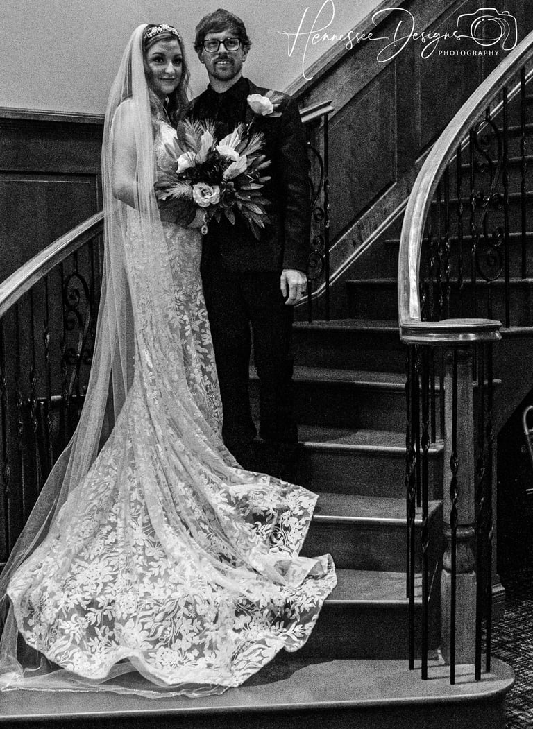 a bride and groom standing on a staircase
