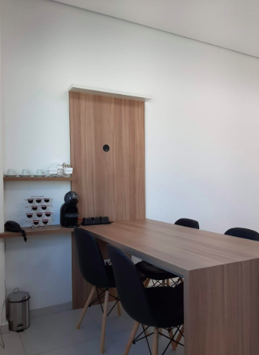 sala de reunião e projetos com mesa, cadeiras e um cantinho do café