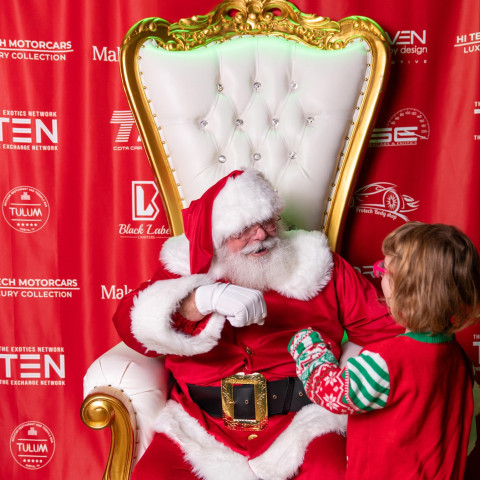The Santa Cowboy gets a fist bump from a Make A Wish participant