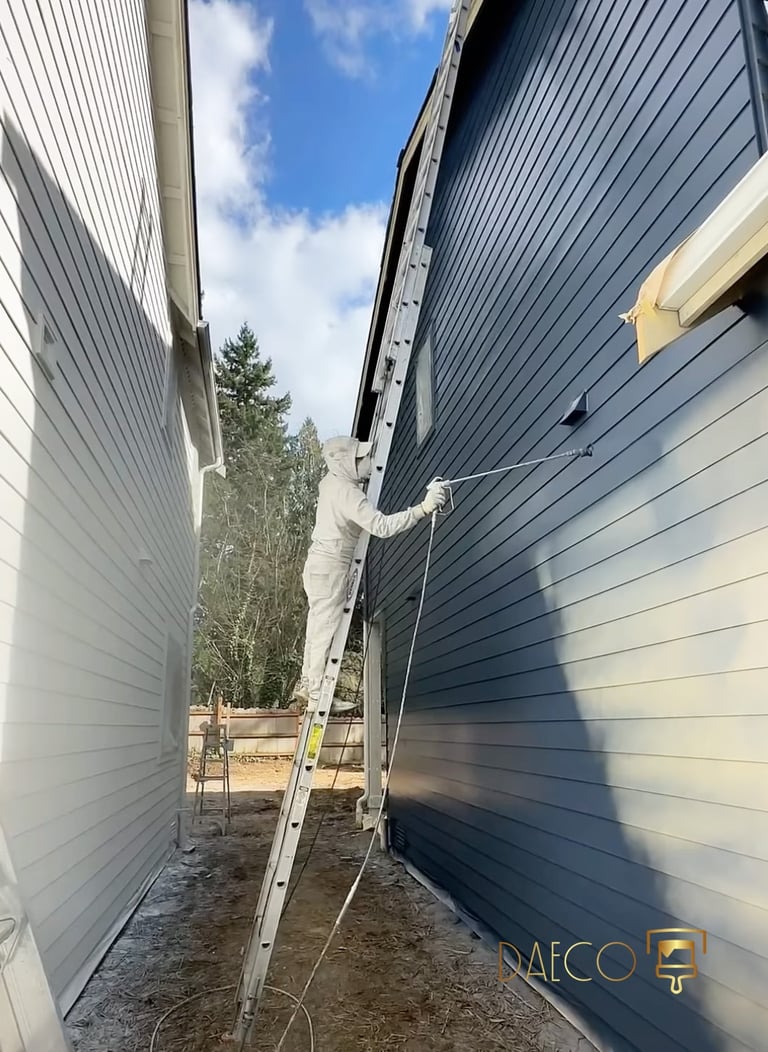 a man is painting a wall of a house in colorado - daeco painiting