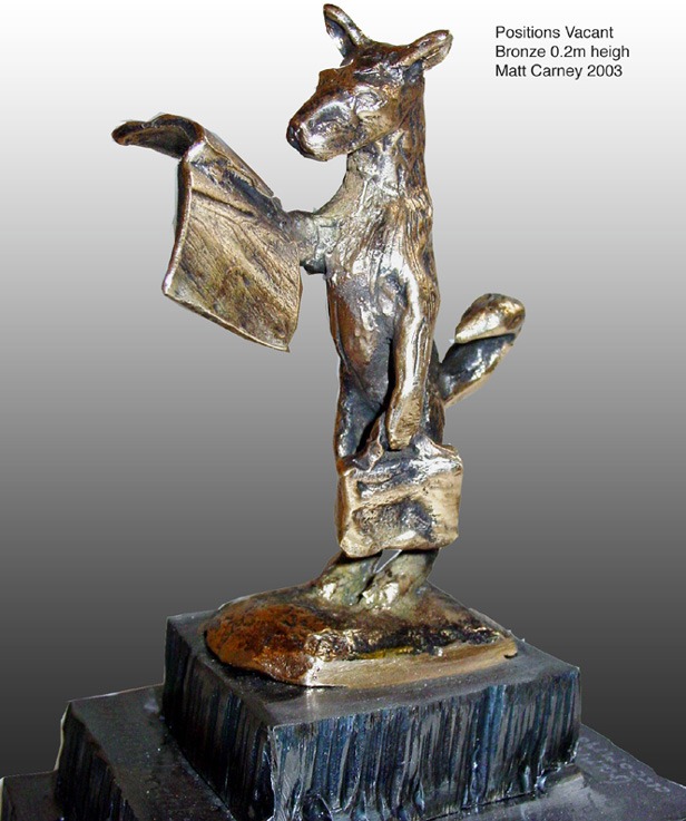 a statue of a dog with a briefcase reading the newspaper