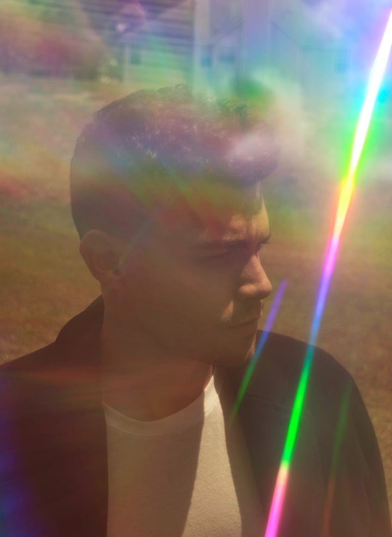 a man with a rainbow - colored light shining through a rainbow - colored light