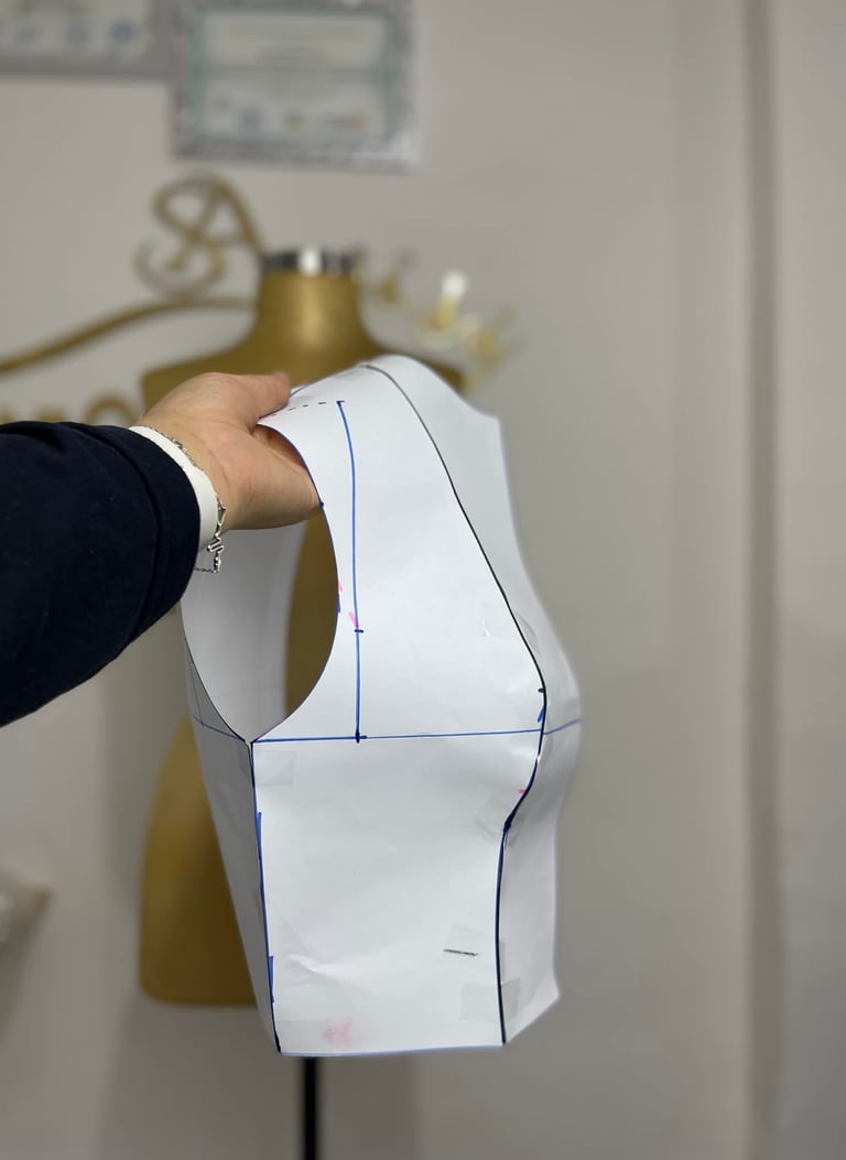 a person holding a piece of paper cut out of a dress