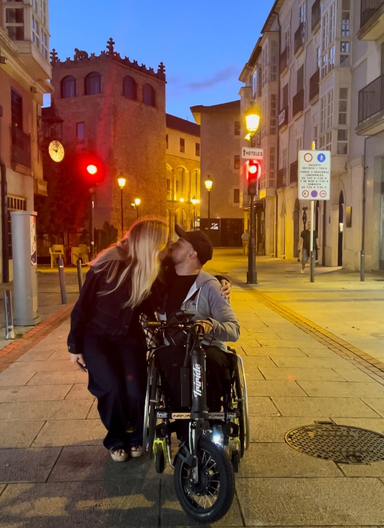 a man and woman kissing on a city street