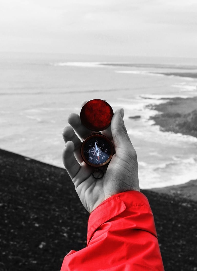a person holding a compass on a beach
