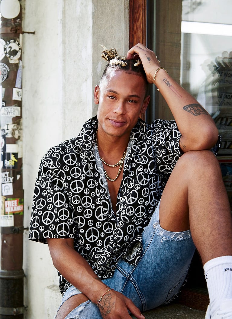 a man sitting on a ledge with a peace sign