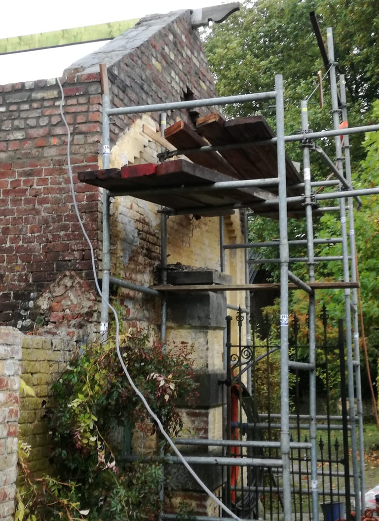 Travaux de restauration sur maçonnerie ancienne avec échafaudage sur façade en briques
