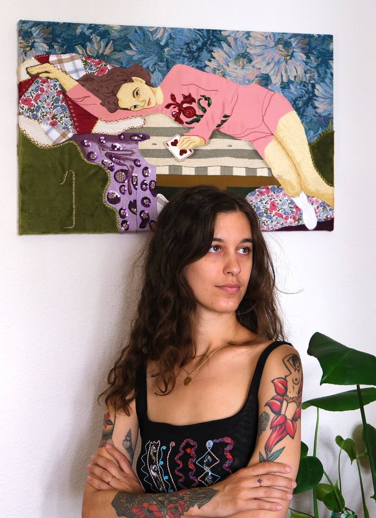 Textile art piece : a woman laying on a couch with a blanket