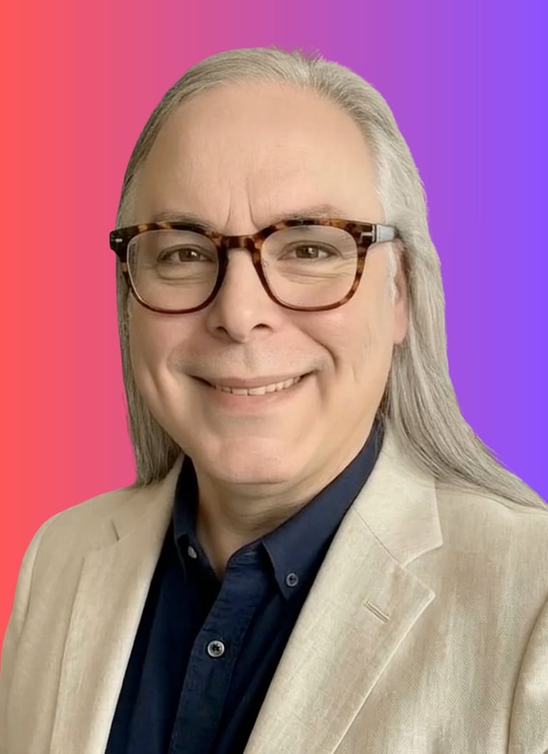 Smiling man with long grey hair and tortoiseshell glasses in a tan blazer against a pink and purple background.
