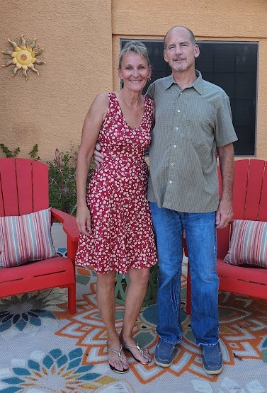 owner and wife standing in front of a house
