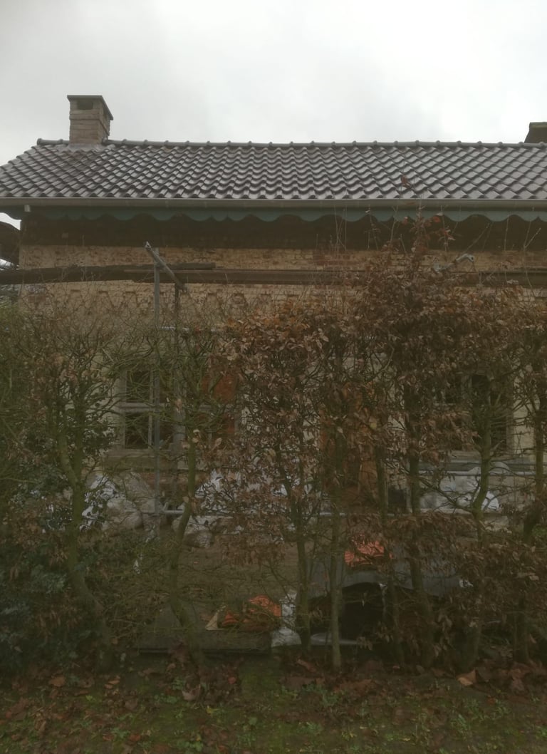 Toiture rénovée avec tuiles neuves sur maison ancienne en briques – résultat final après travaux de