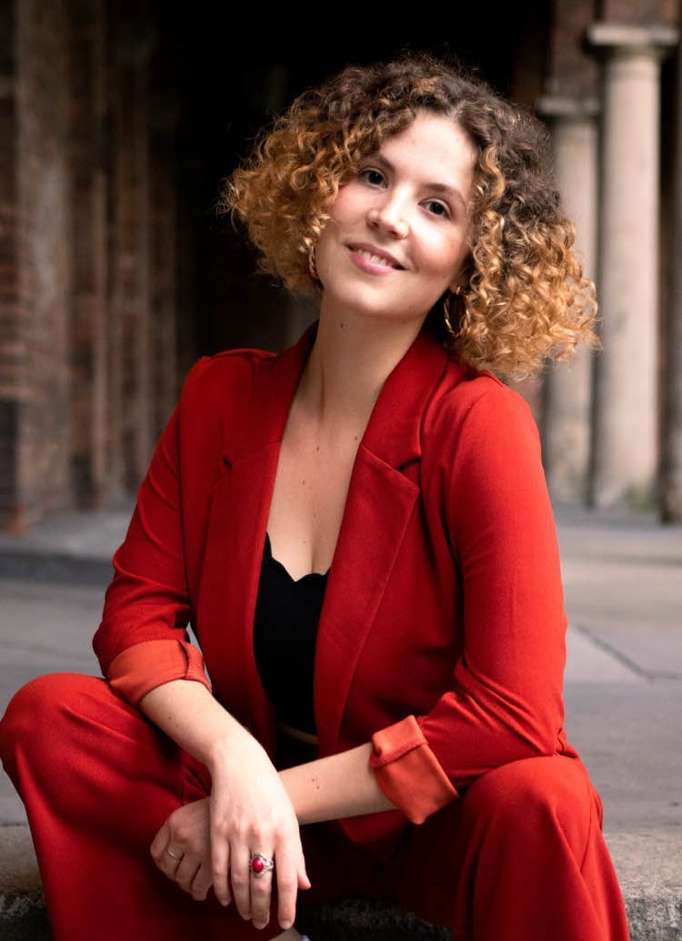 a woman in a red suit and white sneakers