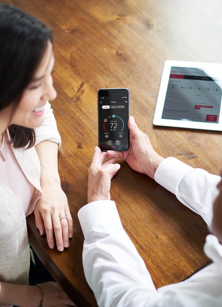 a man and woman sitting at a table with a tablet