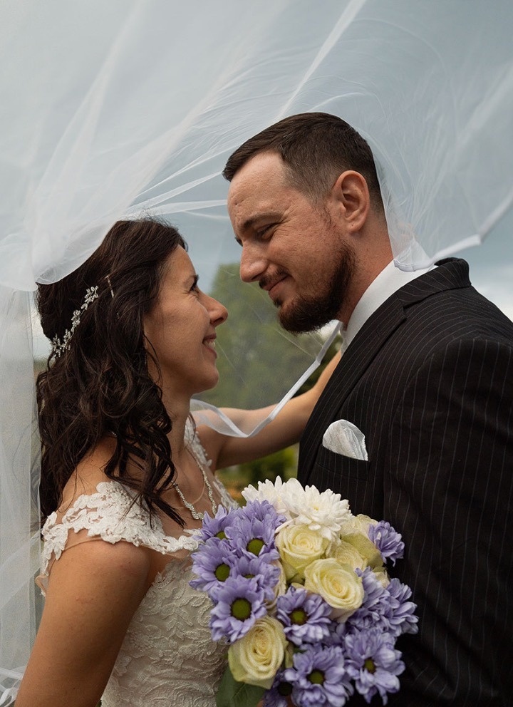 Bride and groom sharing a romantic moment during a wedding photoshoot in Preston Park, Brighton.