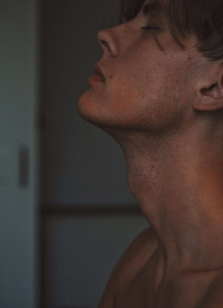 a white man with eyes closed and head tilted upwards, reflecting