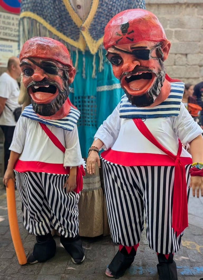 two cabezudos in grotesque pirate costumes with large heads