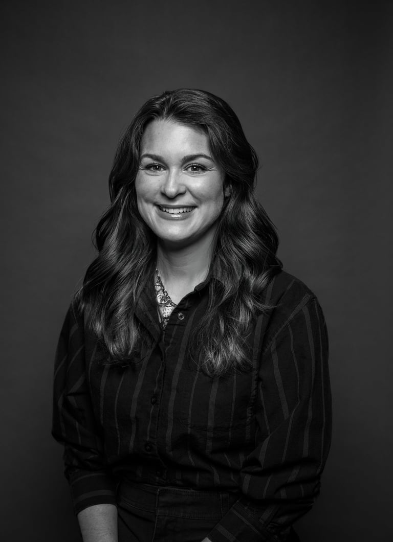 Portrait professionnel en noir et blanc d’une femme souriante aux longs cheveux ondulés 