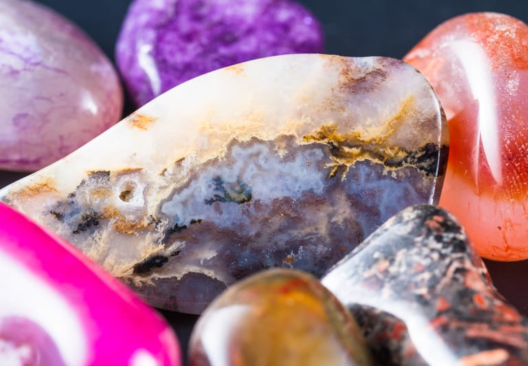 Primer plano de cristales pulidos y ágatas de colores con patrones naturales.