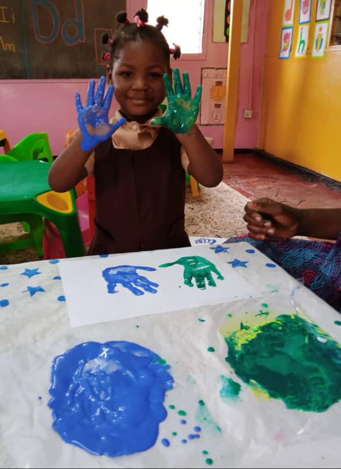 a child's hands painted with blue and green paint