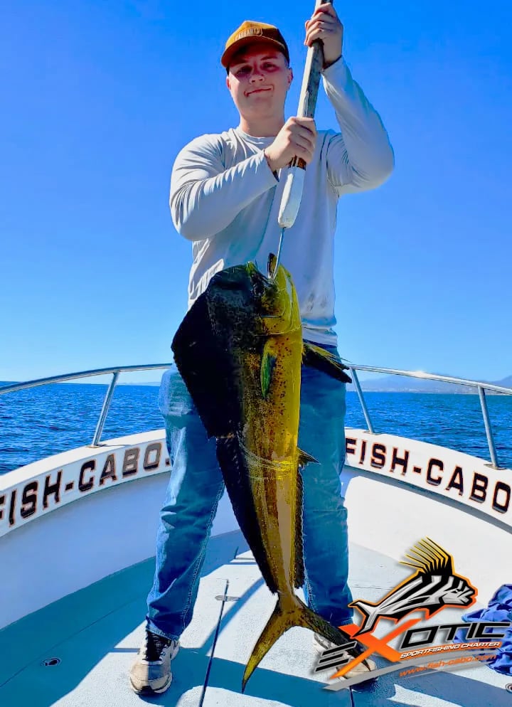 a man holding a fish caught fish on a boat
