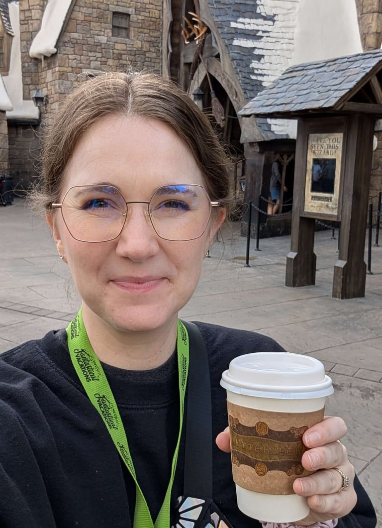 Katie Matzenbacher, Travel Advisor, holding a hot butterbeer in Hogsmeade at Universal Orlando