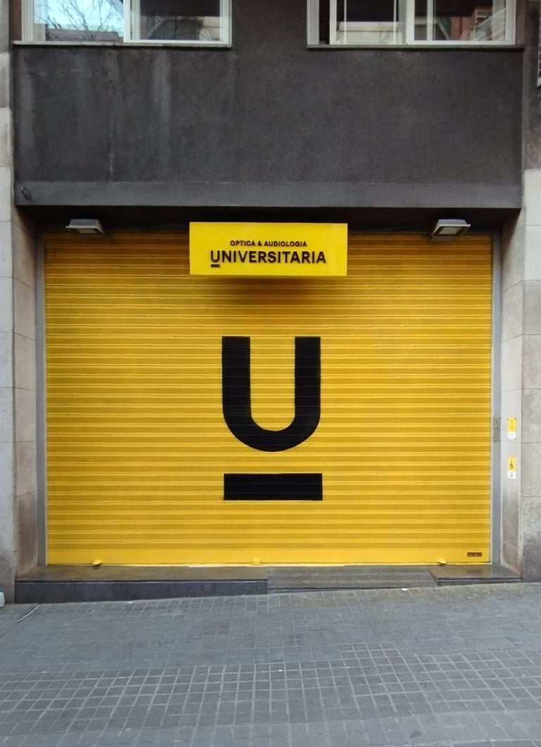 Graffiti en persiana, cierre metálico de Óptica Universitaria, Barcelona