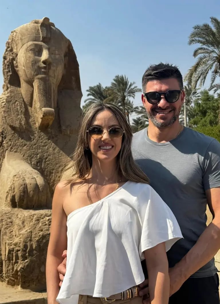 casal de turistas de brasil frente de estatua de esfinge de marmore em memfis com o guia hadi salah