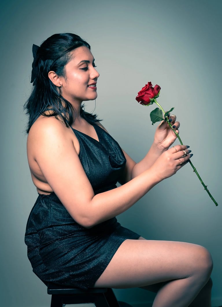 a woman in a black dress sitting on a stool