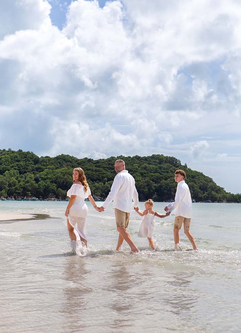 Family walking through shallow water on Khem Beach