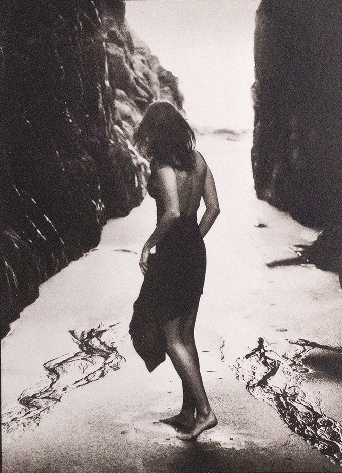 SIlver and Platinum photo of a woman in a black dress standing on a beach