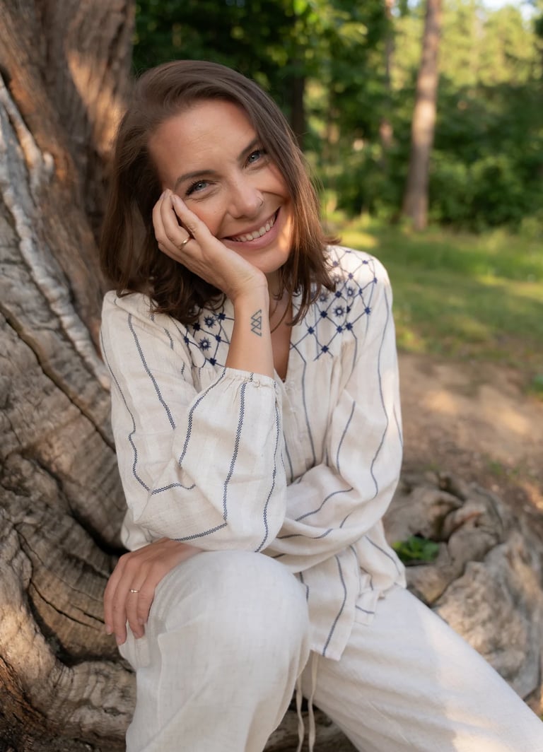 Carina Schwarz, Mentorin und Medium, lächelt in der Natur und begleitet Menschen auf ihrem Weg der Transformation.