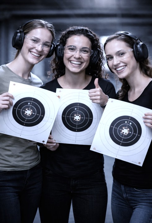 Drei Frauen haben Spass am Schiesstraining. 