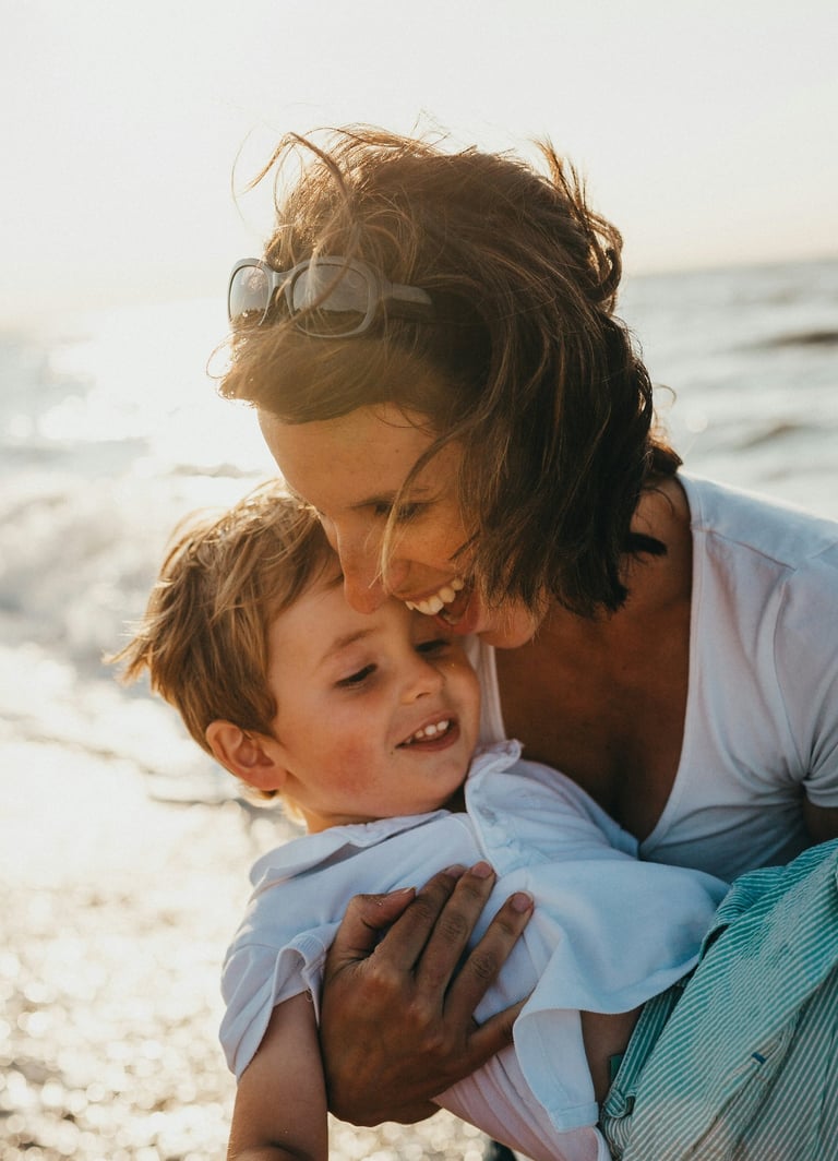 mother holding son at the beach