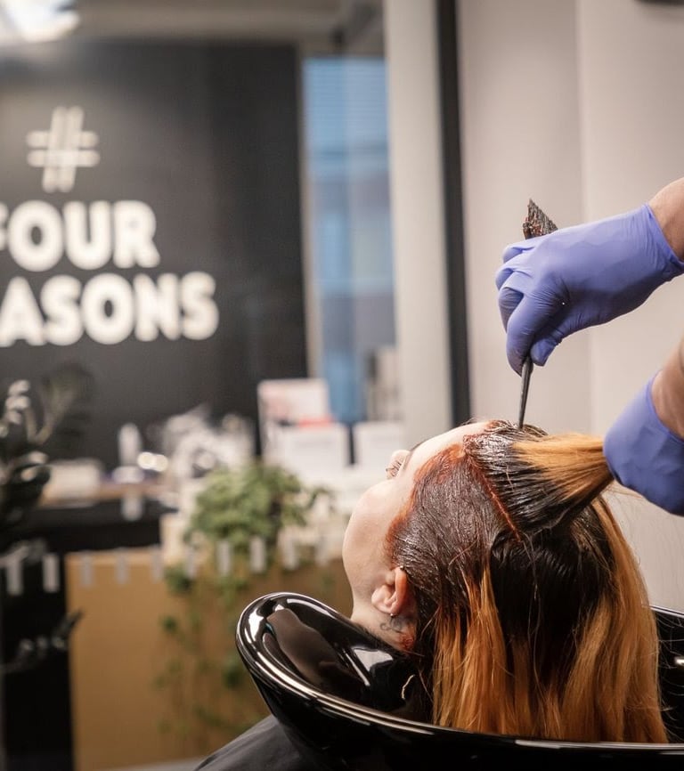 a woman is getting her hair cut by a hairdresser