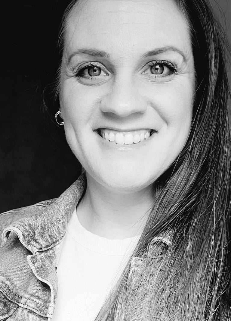 black and white photo of a woman's face with her hair down to one side and smiling