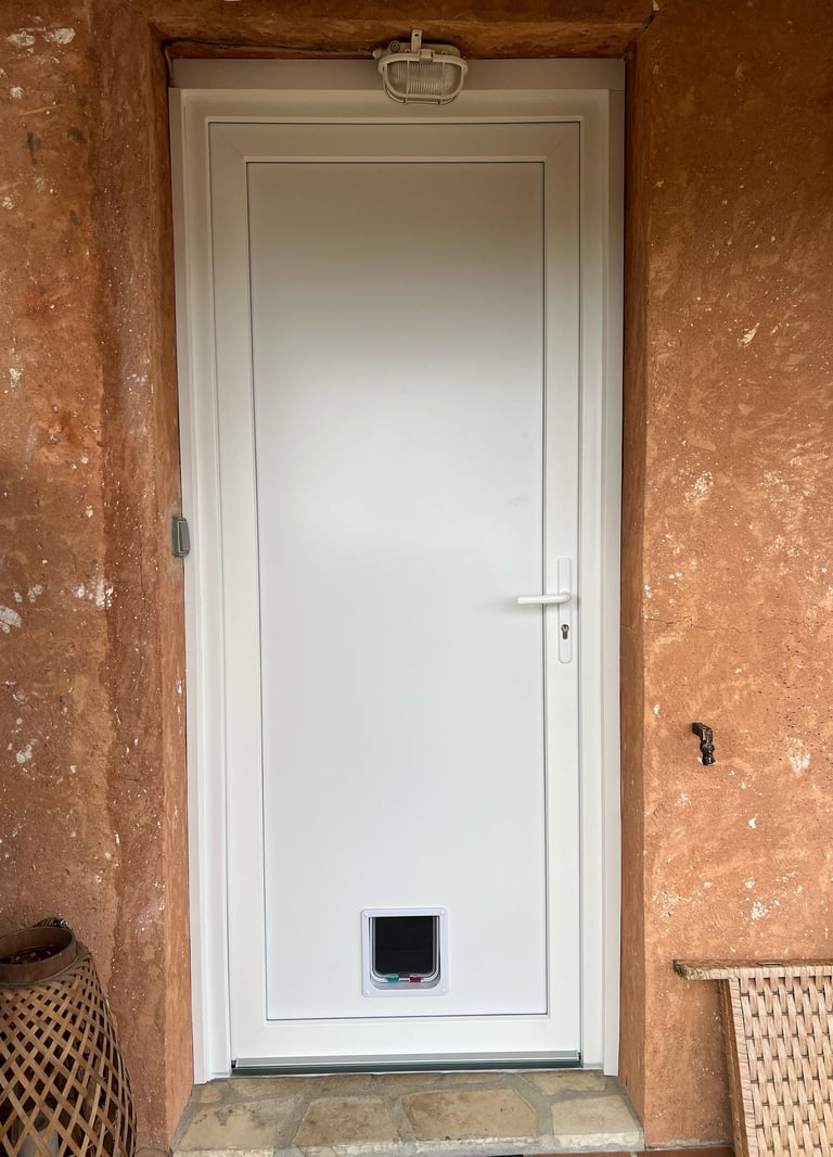 Installation d'une porte d'entrée en PVC blanc avec chatière intégrée par Homestores.